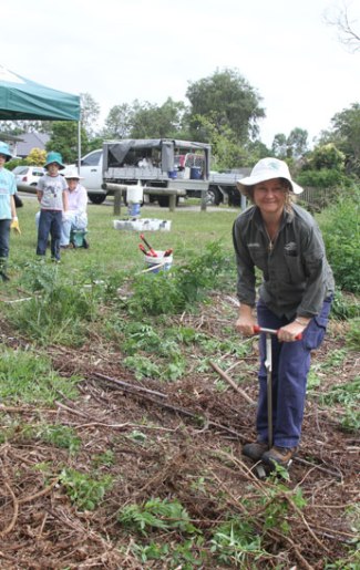 MBRC Bushcare officer Wendy Heath uses a special tool ahead of revegetation planting at the end of McConachie Court.