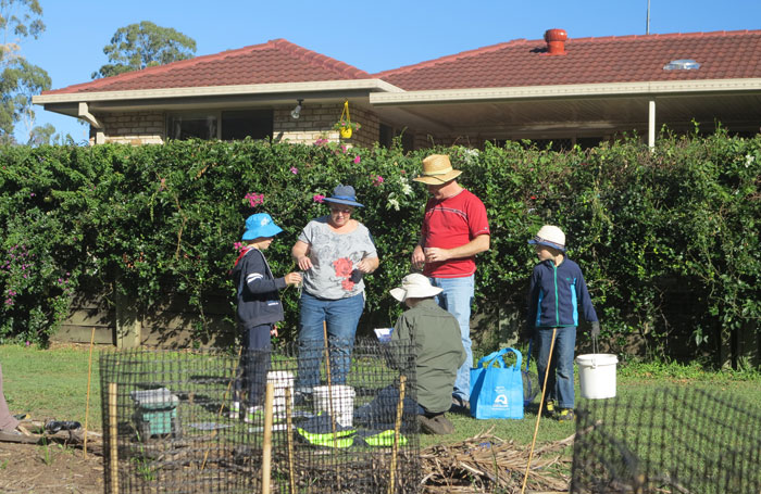 Nicole Byrne helps a volunteer family identify some of the aquatic invertebrate samples taken from the nearby stream