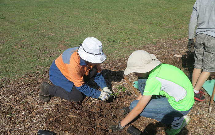 An Albany Hills State School student gets a few pointers from Dawn Road Reserve Bushcare group patron, Janet Mangan.